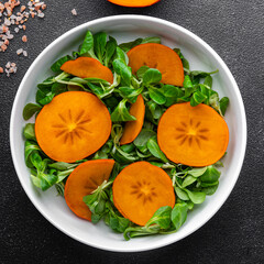 persimmon salad green lettuce salad fresh meal food snack on the table copy space food background rustic top view 