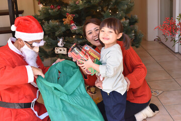 サンタクロースからプレゼントをもらって喜ぶ女の子