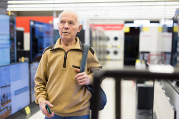 senor man pensioner buying modern digital televisor with smart tv in showroom of digital electronic goods store