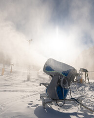 Snowmaking machine snow cannon or gun in action on a cold sunny winter day in ski resort Kranjska Gora, Slovenia