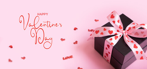 Happy Valentines Day text and present gift box with bow on pink background. Valentines Day greeting card