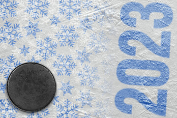 A fragment of an ice arena with a winter pattern and a hockey puck