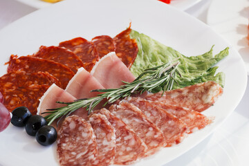 slices of sausage grapes on the festival table .