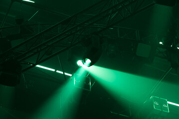 Dark and green background with concert stage light. Moving head light beam.