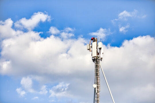Bauarbeiter/Techniker auf einem Mobilfunkmast zum aufrüsten auf 4G 5G LTE