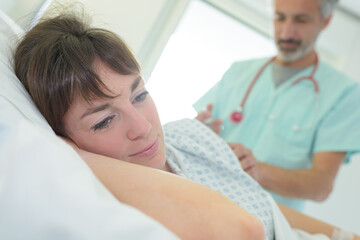 patient looking away as doctor performs procedure on her