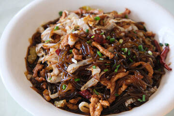 close up a plate of pickle and potato noodles stir-fried shredded pork meat. Traditional dish in Hubei,China