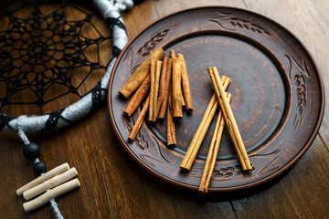 Cinnamon sticks on a clay plate vertically close up