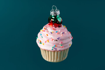 Christmas sweet cupcake bauble on dark green background