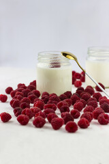 Homemade yogurt with raspberries. Jars of yogurt surrounded by raspberries. Space for text