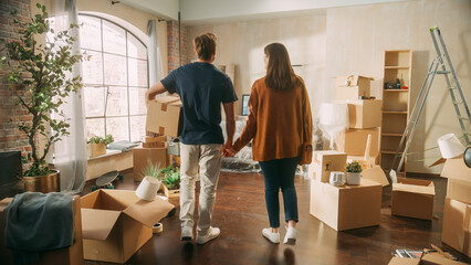 Fototapeta na wymiar Family New Home Moving in: Happy and Excited Young Couple Enter Newly Purchased Apartment. Beautiful Family Happily Holding Hands. Modern Home Ready for Decorations