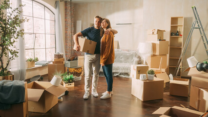 Fototapeta na wymiar Family New Home Moving in: Happy and Excited Young Couple Enter Newly Purchased Apartment. Beautiful Family Happily Embracing, Imagining Future. Modern Home Ready for Decorations