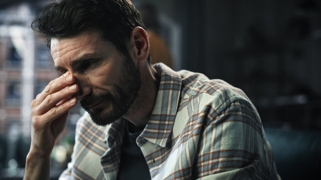 Dark Gloomy Portrait of Fragile Emotional man Crying being Bullied by Partner. Couple Arguing and Fighting Violently. Domestic Violence, Emotional Abuse. Rack Focus with Girfriend Screaming