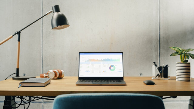 Laptop Computer with Software Platform Screen Display Standing on a Desk. Efficiently Minimalistic Design of Modern Office Space. Economy, Finances, Profit Charts, Graphs and Statistics of Income - Powered by Adobe