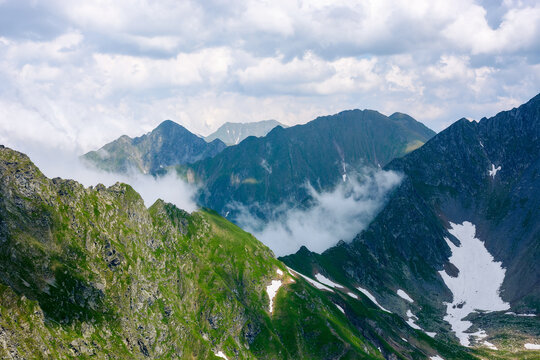 wonderful summer scenery of romania. fagaras mountain range. bright morning. green rocky cliffs and clouds. beautiful nature background