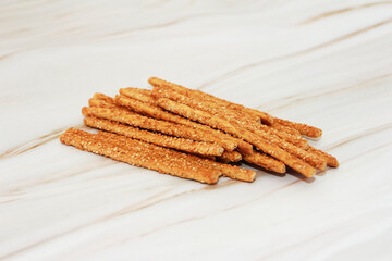 Long dry sesame bread sticks on a gray marble background