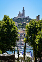 View of the Basilique Notre-Dame de la Garde on the hill above the port of Marseille - 555124705