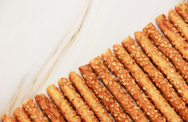 Long dry sesame bread sticks on a gray marble background