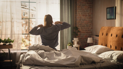 Beautiful Young Woman Waking up in the Morning, Stretches and Gets Out of Bed, Sun Shines From the Apartment Window, Ready for Opportunities, Achievements, Adventures. Medium Shot