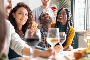 Group of friends having fun together drinking beers and wine - Social gathering life style , friendship and leisure concept