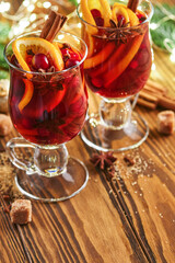 Christmas hot mulled wine. Glasses of mulled wine with aromatic spices cinnamon, anise, sugar and fir tree branches with bokeh and decorations. Traditional Xmas festive drink. Winter Christmas drink.