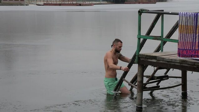 Bathing in icy water. Diving into icy water. Ice Swimming. Bathing in the ice-hole. 