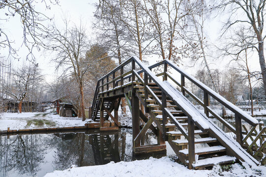 A snow covered wooden bridge in museum village Lehde in winter, Spree Forest - Germany
