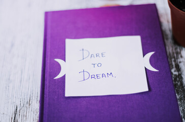 Dare to dream inspirational message on diary close up 