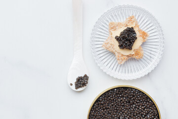 Black caviar appetizers bread star on a white background top view