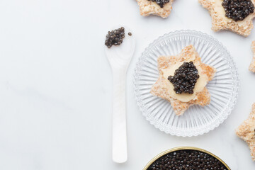 Black caviar appetizers bread star on a white background top view