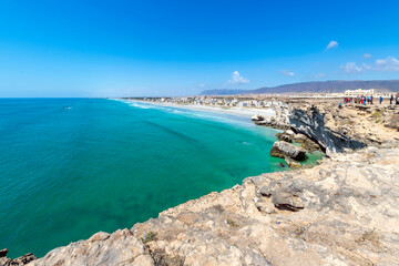 Fototapeta na wymiar The village of Taqah and it's white sandy Taqah Beach seen from the cliffs rising above the Arabian Sea near Salalah, Oman.