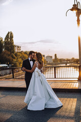 Obraz premium bride and groom dance on a bridge 