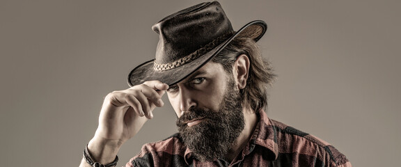 Portrait of young man wearing cowboy hat. Cowboys in hat. Handsome bearded macho