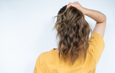 Fototapeta premium Rear view of woman holding her long hair before tire it.