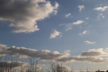 blue sky the sun the sun rays filtering through the clouds the sun after the rain clouds the white cloud trail left behind the plane