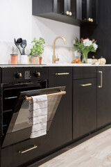 stylish kitchen with dark furniture and built in oven