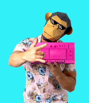 Anonymous male in pixel monkey mask with vintage boombox showing horn gesture