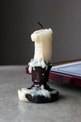 An extinguished candle on the table in front of the frame. Soft focus