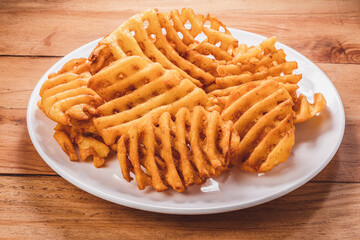 Fried Wafer Potato in white plate on wooden background, Fried wafer potato on wooden background.