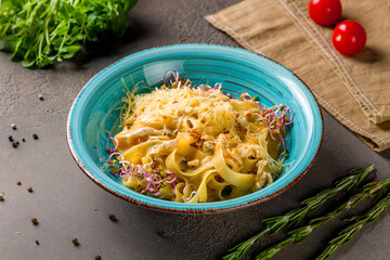 Pasta with chicken and mushrooms on brown table