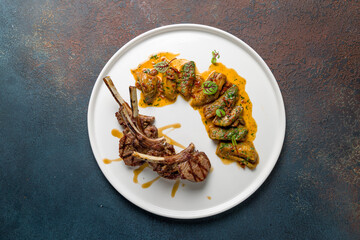 Rack of lamb with auberdine with sauce on white plate top view © Алиса Королевская