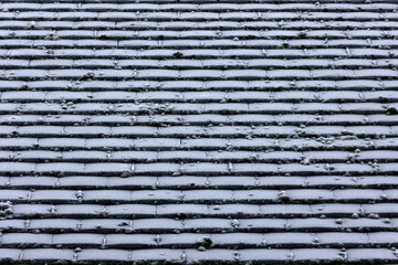 Background texture of old clay roof tiles covered in frost