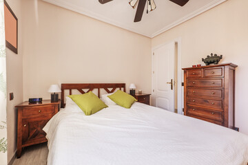 Double bedroom with reddish teak wood and a ceiling fan with wooden blades