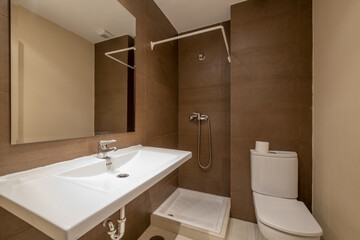 Bathroom with white porcelain sink without cabinet, square beveled mirror on the wall and square shower tray