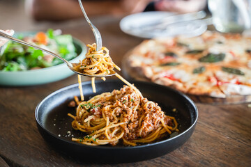 Eating food. people eating Italian food Pasta, Pizza, Salad on the table.