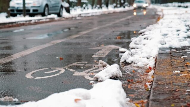 Contraflow Bike Lane Symbol Painted on Asphalt Street Covered in Snow on Winter Day