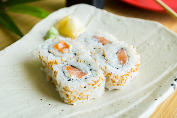 Uramaki with salmon. In the same way it is a rolled sushi, only that the external layer is sushi rice and the internal one is nori seaweed.