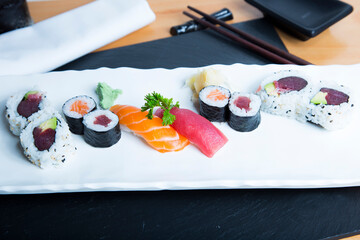 Set of sushi with variety of makis, nigiris and sashimi with fine fish like salmon and tuna.