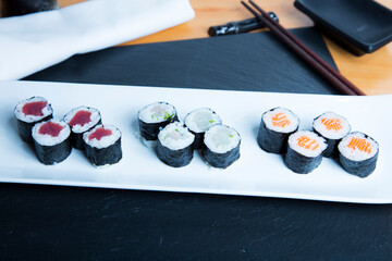 Set of sushi with variety of makis, nigiris and sashimi with fine fish like salmon and tuna.