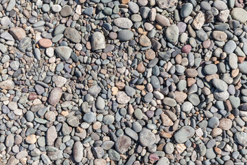 Gray coastal pebble, top view, close-up background texture